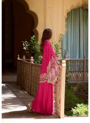 Vibrant Fuchsia Ethnic Wear Against Traditional Indian Architecture